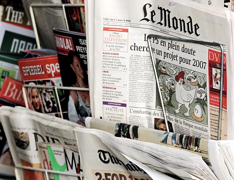 Newspapers on a rack showing the fold